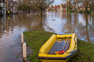 Yello dinghy in the flooded street of a UK town