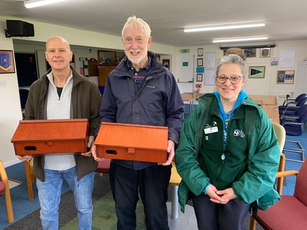 Two men holding swift nest boxes