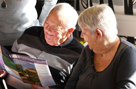 A couple smiling as they read the Thatcham Town Newsletter